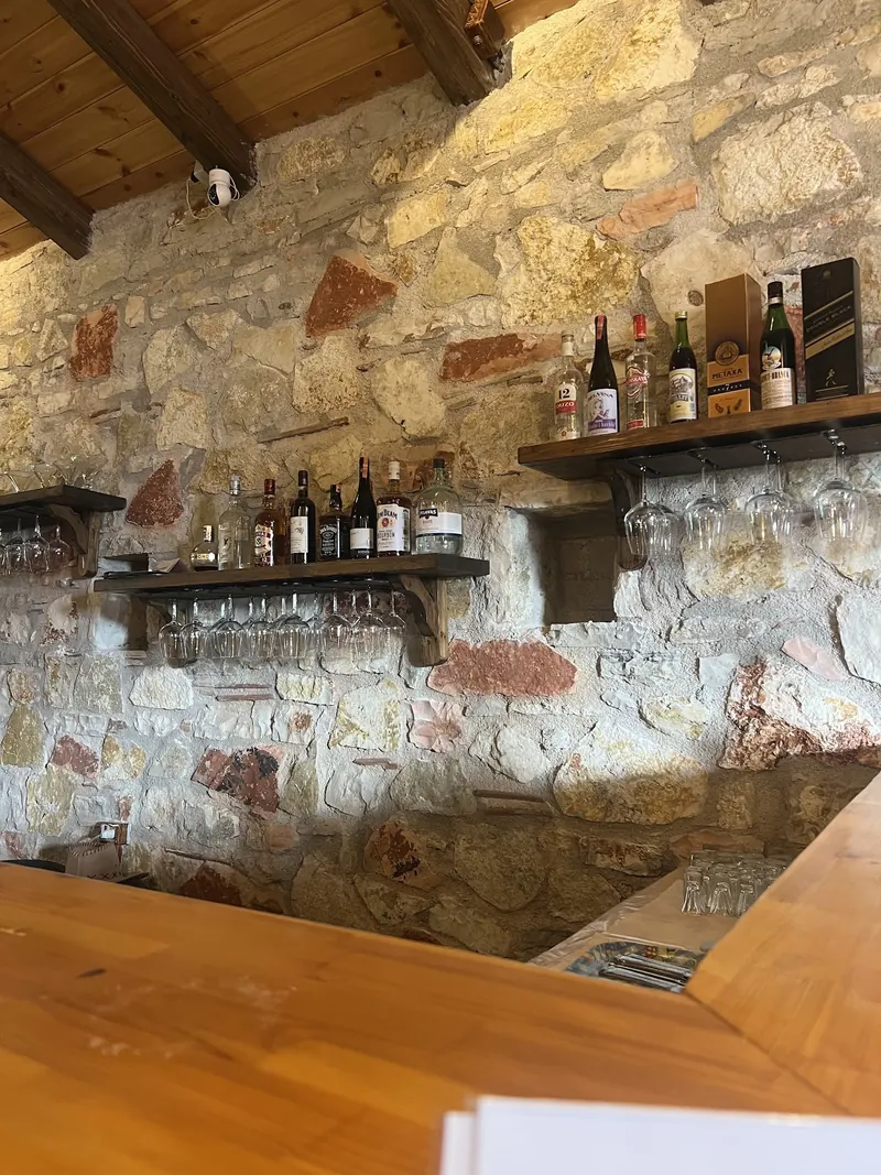 The stone-walled bar with wine glasses and bottles on the shelves