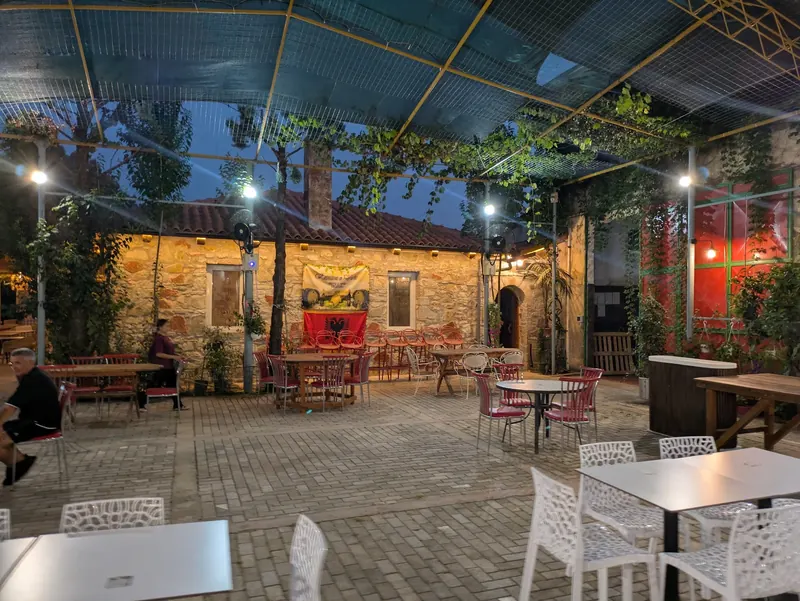 The courtyard in the evening, lit under the vine-covered roof