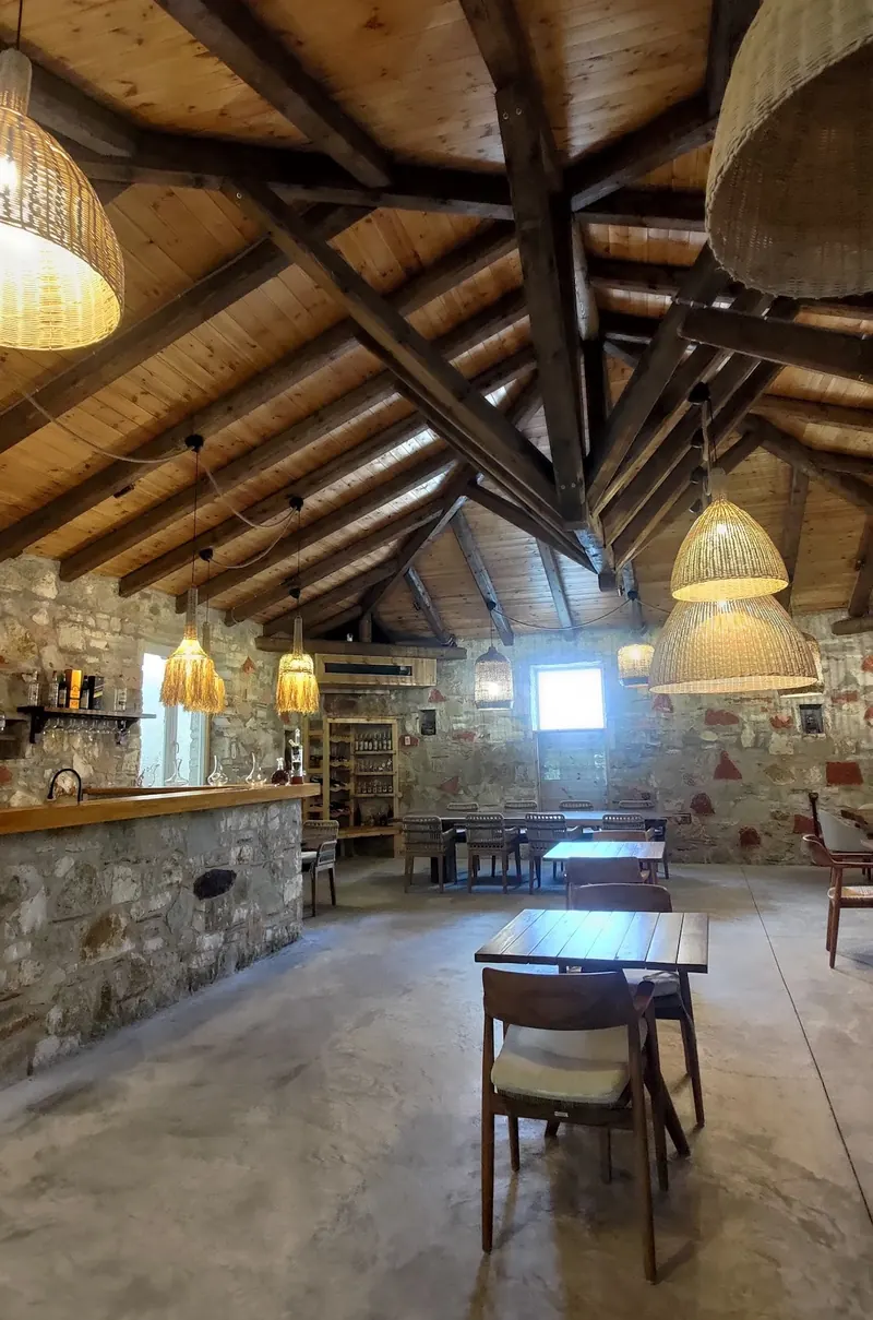 The timber roof beams and stone walls of the tasting hall