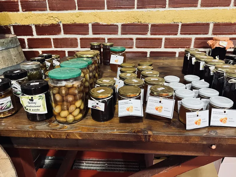 Jars of olives, jams and preserves on a wooden table